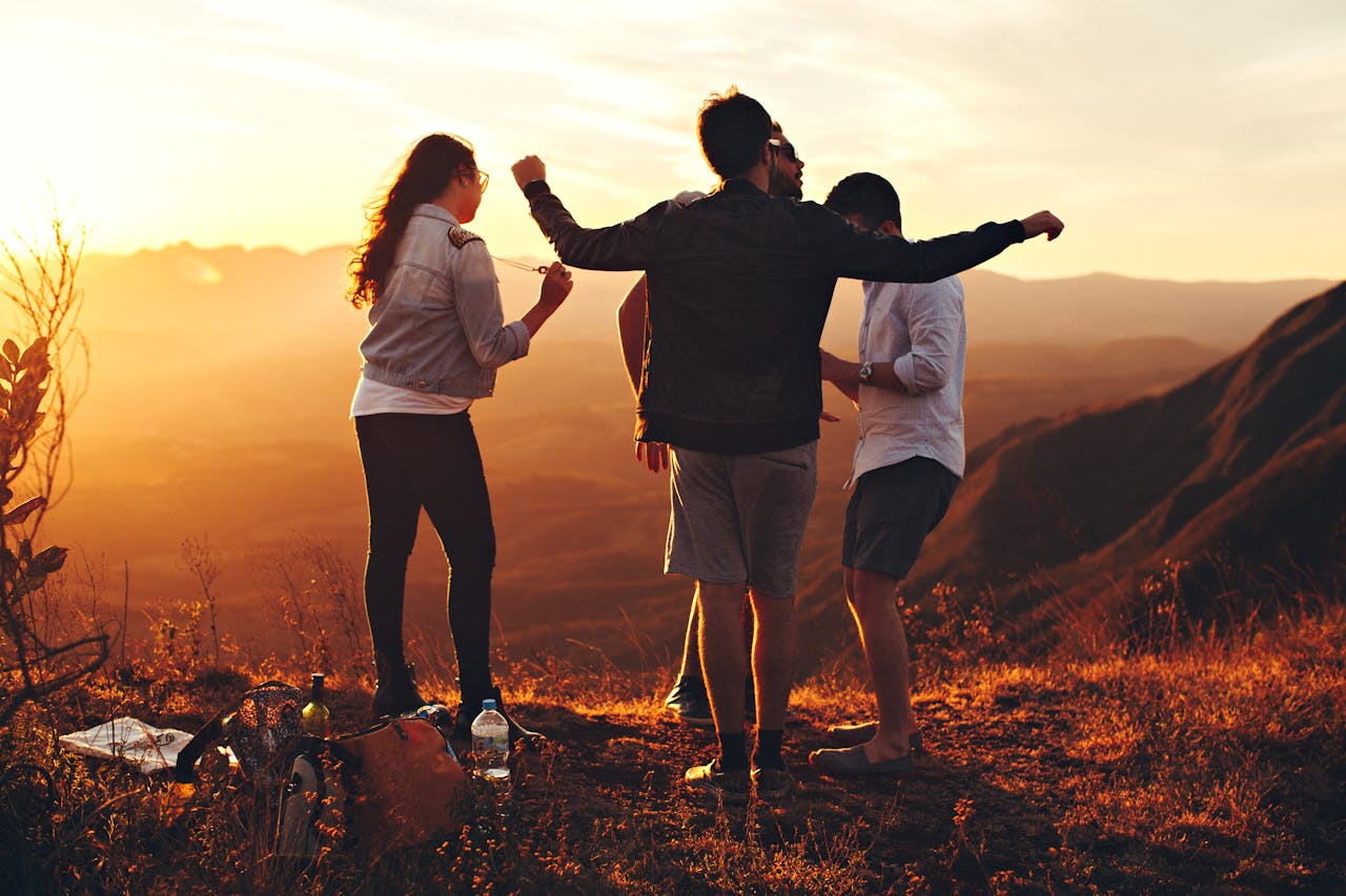 hero-img-01 Joyful group of young adults enjoying a sunset view in a mountainous landscape in Brazil.
