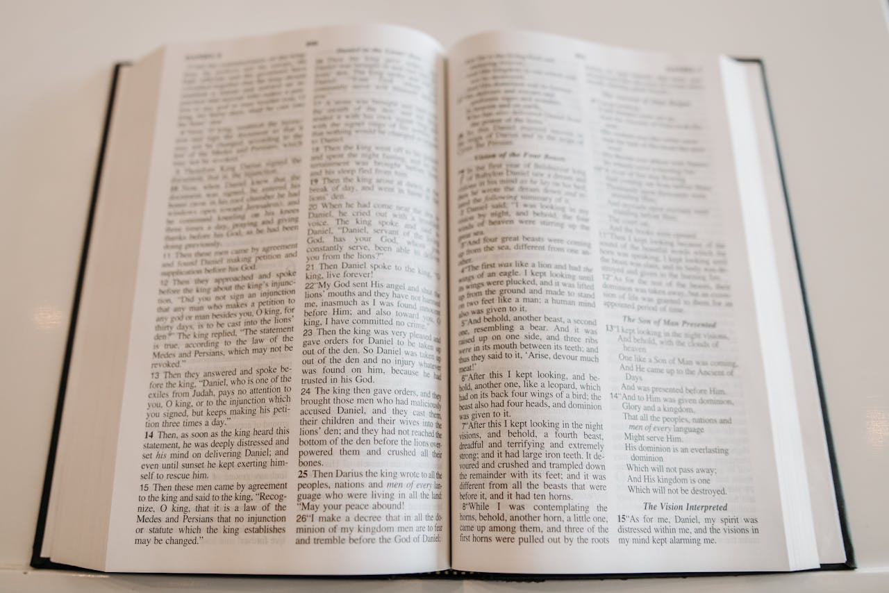 our-services-2 An open Holy Bible on a wooden table, showcasing scripture text, ideal for religious and spiritual themes.